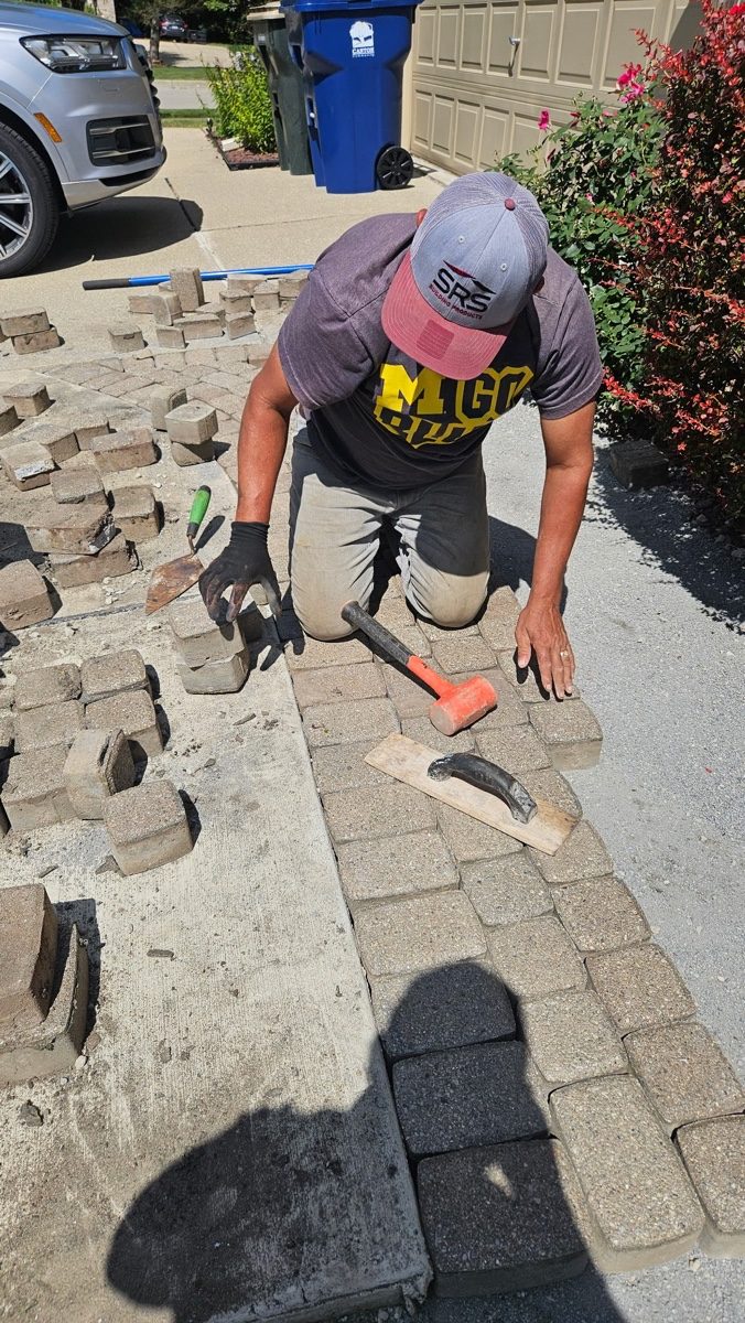 XXX Landscape crew laying pavers over a compacted aggregate base